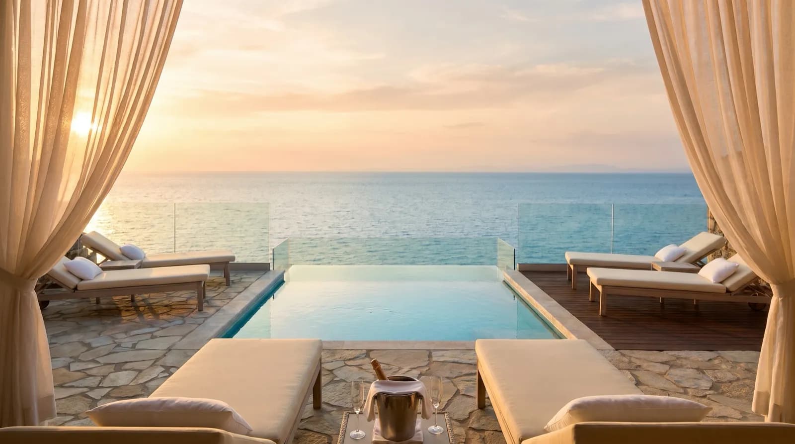 Private oceanfront suite terrace with a plunge pool at sunset