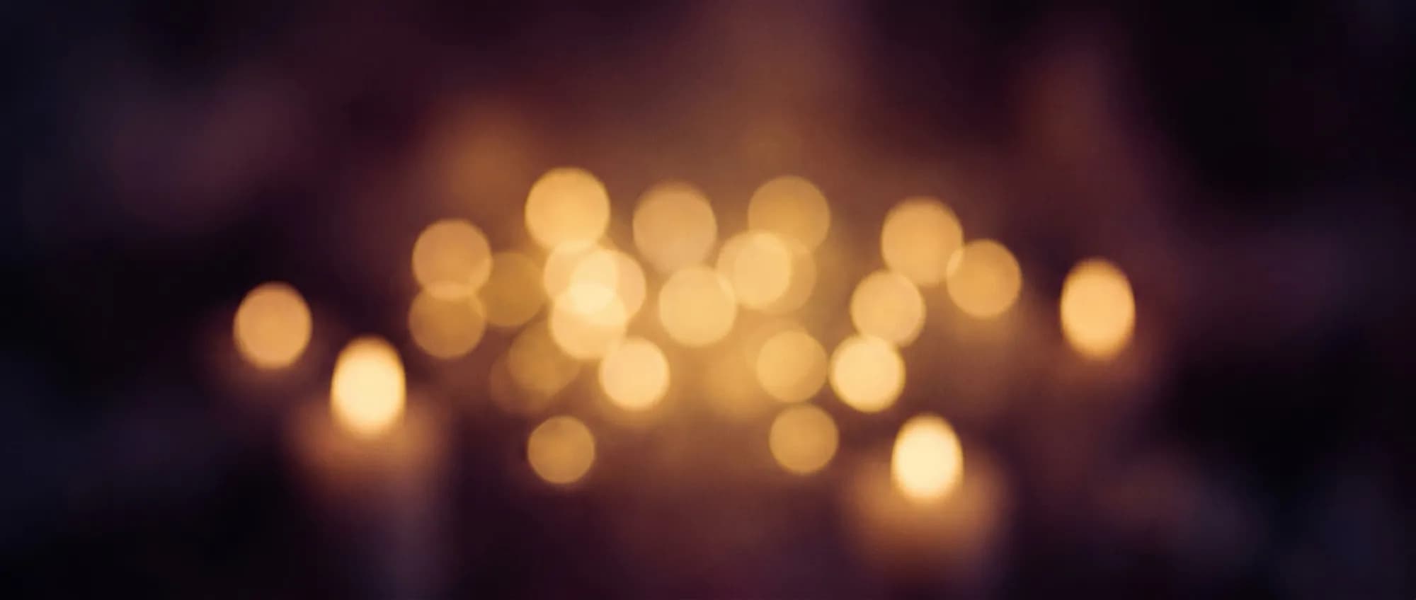 Warm candlelit bokeh at a private lifestyle party